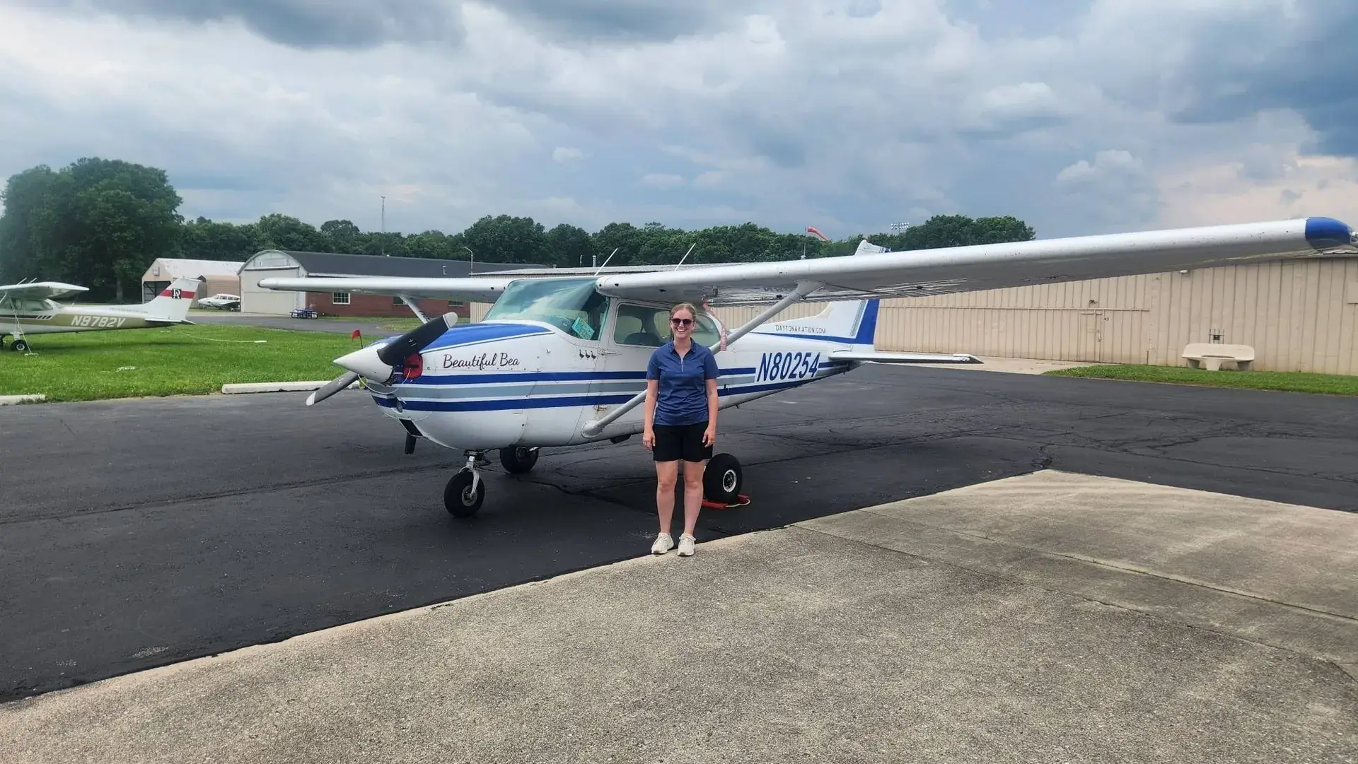 Student pilot standing in front of a Dayton Aviation Services Cessna 172